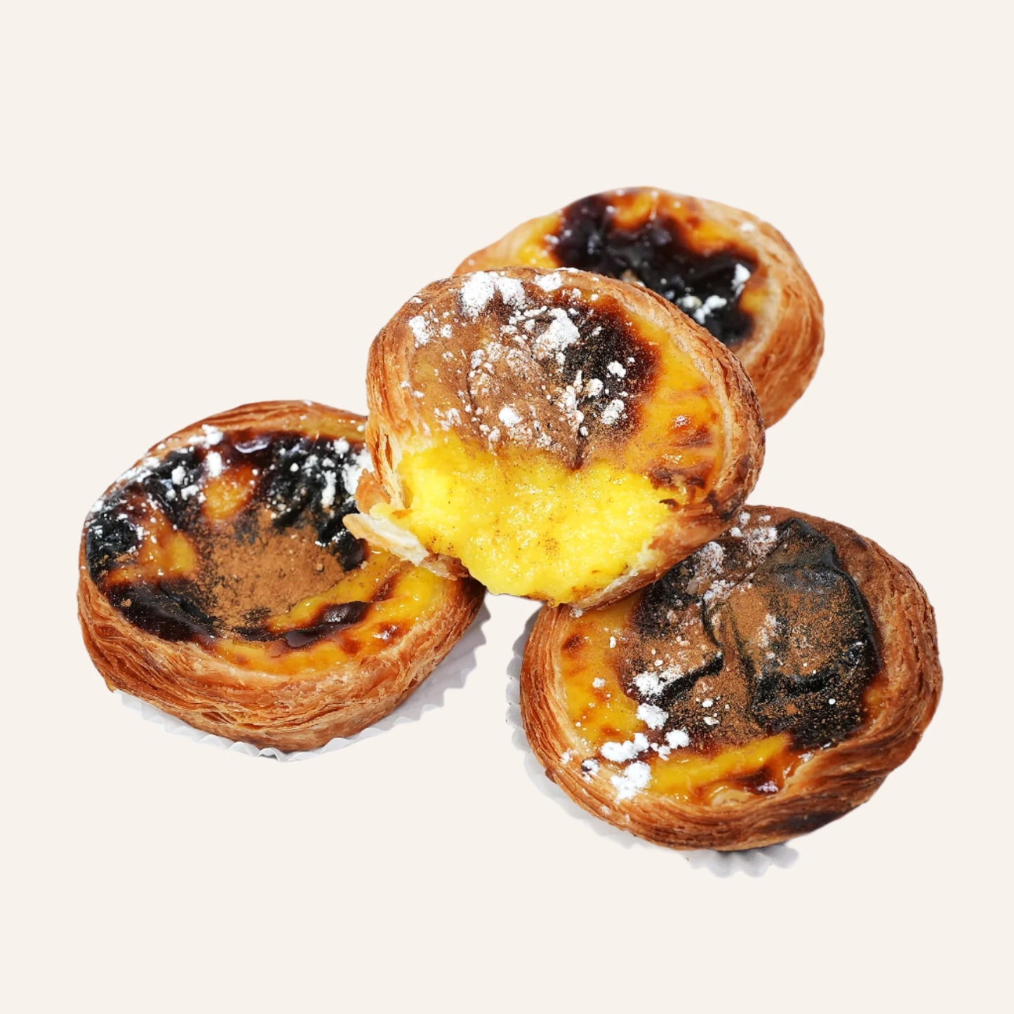 four pasteis de nata with sprinkled sugar and cinnamon on top