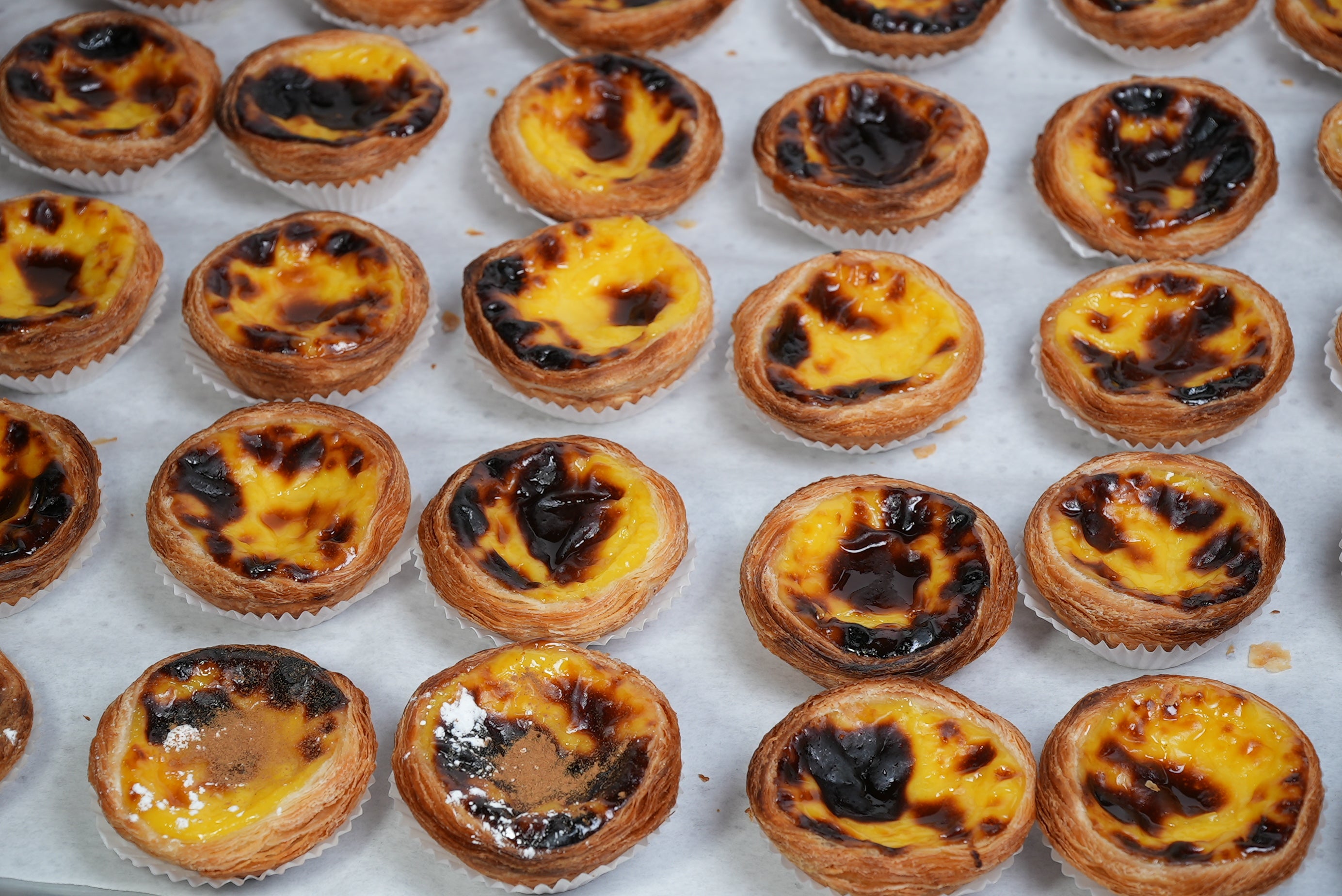 a bunch of pasteis de nata with canela and sugar on top