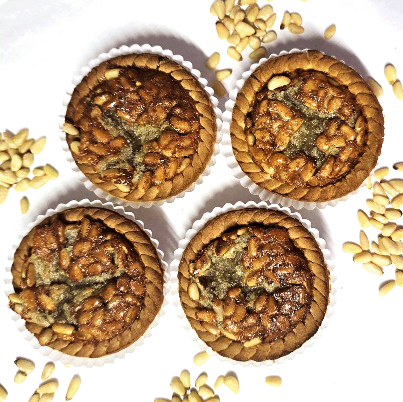 four small pignoli pies over a white table